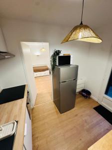 een kamer met een keuken met een koelkast en een lamp bij Appartement tout neuf avec patio - 31 in Dax