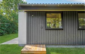 ein Haus mit einer Holzbank davor in der Unterkunft Nice Home In Odder With Wifi in Odder
