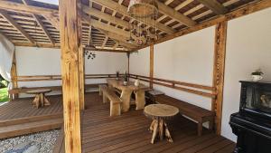 a porch with wooden benches and a table and a stove at Ziediņi in Auciems
