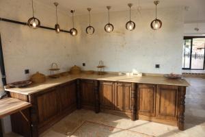 a kitchen with wooden cabinets and lights on the wall at Erdu Cappadocia Stone House in Avanos +15 photos