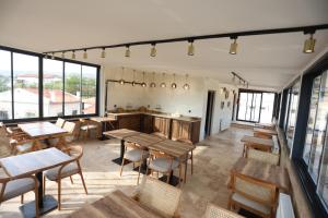 a restaurant with wooden tables and chairs and windows at Erdu Cappadocia Stone House in Avanos