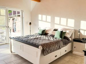 een slaapkamer met een groot bed met groene kussens bij Villa Neufunnixsiel in Neufunnixsiel