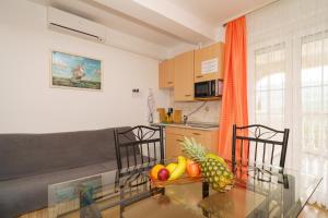 a kitchen and a dining room with a glass table at Kuca Orhidea in Crikvenica