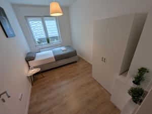 a small bedroom with a bed and a window at Gemütliche Ferienwohnung zum Wohlfühlen am Paderquellgebiet in Paderborn +4 photos