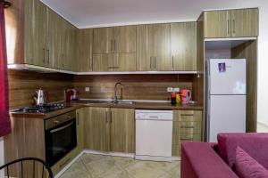 a kitchen with wooden cabinets and a white refrigerator at Kasdreamhill in Kaş