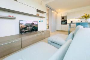 a living room with a tv on a wall at Villamaresicilia appartamento e stanze nel lungomare in Ispica