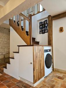a laundry room with a staircase and a washing machine at Cottage de la Plante in Thuré