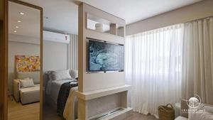 a living room with a television and a fireplace at Modern apt next to Criamigos Park + coffee Day 1 in Gramado
