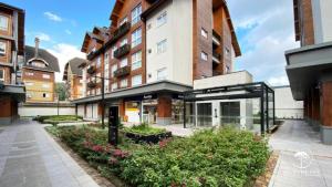 an apartment building with a courtyard with flowers at Modern apt next to Criamigos Park + coffee Day 1 in Gramado