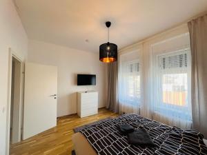 a bedroom with a bed and a television in it at Living Graz Eggenberg Top 17 in Graz