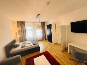 a room with a bed and a desk and a television at Living Graz Eggenberg Top 17 in Graz