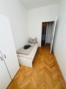 a small bedroom with a bed and a wooden floor at One room 3 - Villa Rebuli in Top 3 in Leitendorf