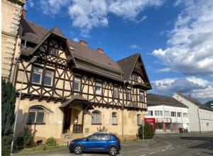 a blue car parked in front of a building at Room in Top 2 Vila Rebuli For 4 people in Leitendorf