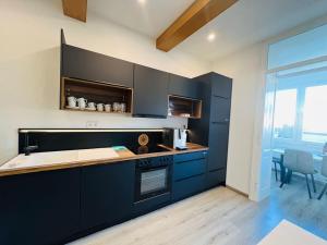 a kitchen with dark blue cabinets and a stove at Big Travel Group Leoben in Leitendorf