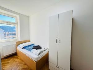 a small bedroom with a bed and a window at Big Travel Group Leoben in Leitendorf