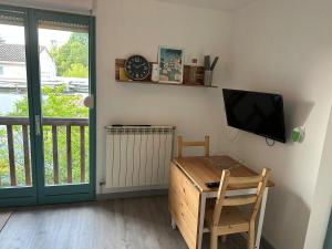 a room with a desk and a tv on a wall at Appartement rénové et lumineux - 130 in Dax