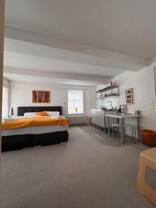 a bedroom with a bed and a desk and a kitchen at Gruppenhaus Harzer Glückauf in Langelsheim