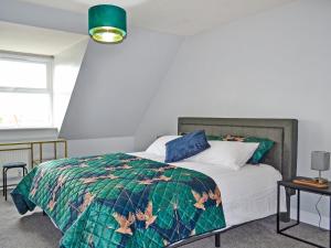 a bedroom with a bed with a green comforter at The Townhouse in Gainsborough