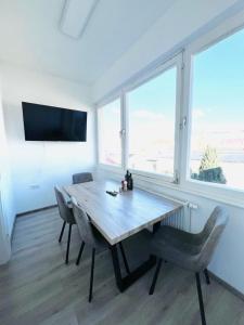 a dining room with a table and chairs and windows at Leoben 3 rooms 3 people Top 4 in Leitendorf