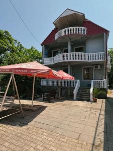 una grande casa con ombrelli rossi davanti di Guest House "Sulo" a Kobuleti