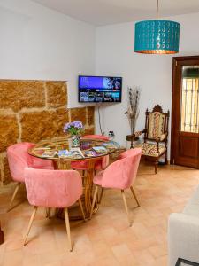 comedor con mesa y sillas rosas en Puerta Romana, en Carmona