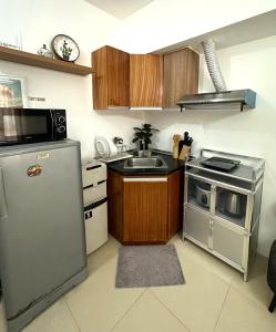 eine Küche mit einem Kühlschrank aus Edelstahl und einer Spüle in der Unterkunft Avida Towers Riala IT PARK Cozy Studio in Cebu City