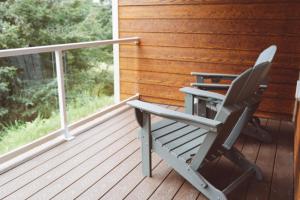 a rocking chair on a porch with a window at Lakeshore Lodging Apartment G in Homer