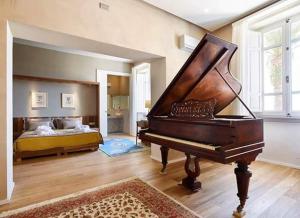 モンティニョーゾにあるRelais Montepepe Winery & Spaのベッドルームにピアノ付きのリビングルーム