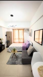 ein Wohnzimmer mit einem Bett und einer Couch in der Unterkunft Avida Towers Riala IT PARK Cozy Studio in Cebu City + 10 Fotos