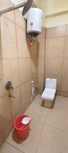 a bathroom with a toilet and a bucket at Sri Arunachalam Residency in Tiruvannāmalai