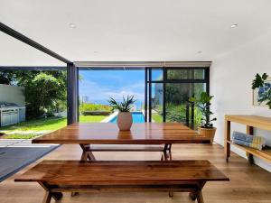 a living room with a wooden table and large windows at Amazing Condo with Pool Fresnaye in Cape Town