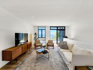 a living room with a couch and a tv at Amazing Condo with Pool Fresnaye in Cape Town