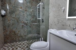 a bathroom with a shower and a toilet and a sink at VSS La Puntilla in Arecibo - Stylish Coastal Getaway in Arecibo +20 photos