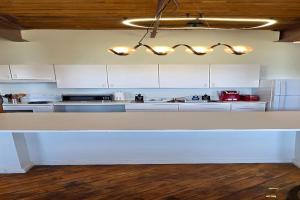 a kitchen with white cabinets and a white counter top at Detroit MotorCity Riverfront Loft in Detroit