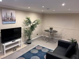 a living room with a couch and a tv and a table at Abbeygreen Village House in Lesmahagow +9 photos