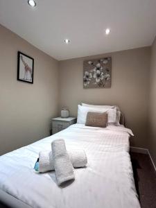 a bedroom with a large white bed with towels on it at Abbeygreen Village House in Lesmahagow