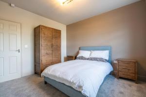 a bedroom with a blue bed and a wooden cabinet at Cartercroft, Sheffield in Sheffield