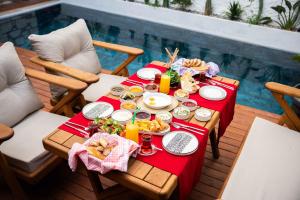 una mesa con comida y bebidas junto a una piscina en Karnelyan Alaçatı, en Cesme