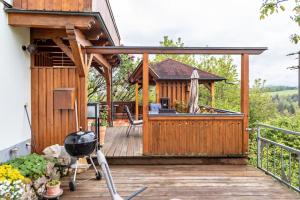 una terraza de madera con cenador en Ferienwohnung am Fuchsbühl, en Schopfheim