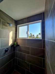 a bathroom with a large shower with a window at Paktinemi Diamante Fantastic View Beach Club in Acapulco