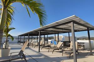 - un pavillon avec des chaises et des palmiers sur une plage dans l'établissement Costa Paraíso D-19 1 Recamara, à Bucerías