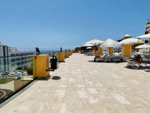 a patio with chairs and umbrellas on top of a building at Puesta del sol en playa arena in Puerto de Santiago