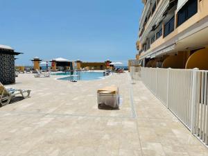 a balcony of a building with a pool and a fence at Puesta del sol en playa arena in Puerto de Santiago +42 photos