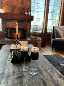 two wine glasses on a wooden table with a candle at "Rockyhill" Affordable beautiful luxury Lodge Idre sauna in Idre