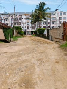 an empty dirt road in front of some buildings at Mama Abayi Fakhi in Mombasa