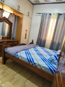 a bedroom with a bed and a dresser and a mirror at Mama Abayi Fakhi in Mombasa