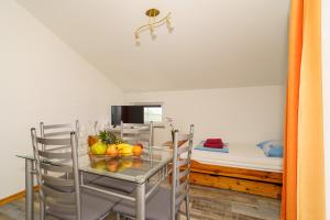 a dining room with a table and chairs and a bed at Kuca Orhidea in Crikvenica