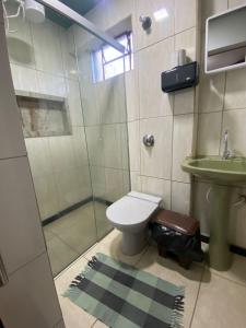 a bathroom with a toilet and a shower and a sink at Pousada Tamboril in Brumadinho +14 photos