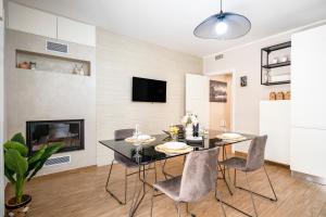 a dining room with a table and chairs and a tv at DaDa Luxury Home in Bari