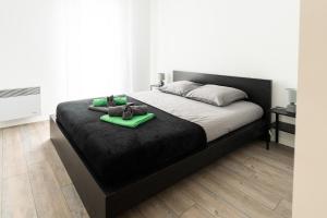 een slaapkamer met een bed met een zwart bedframe en groene handdoeken bij Horizon Paisible - Piscine et parking ! in Toulouse
